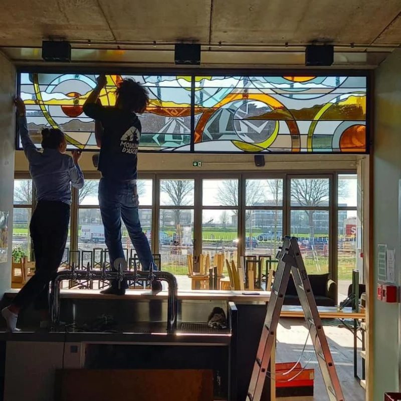 Pose d'un vitrail en intérieur d'une brasserie